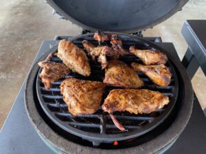 Chicken is being grilled on one of the tables